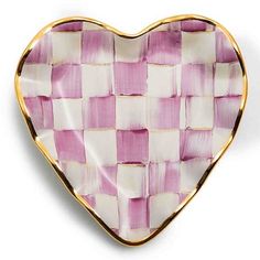 a pink and white checkered heart shaped dish on a white surface with gold trim