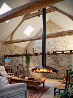 a living room filled with furniture and a fire place in the middle of the room