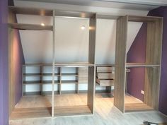 an empty room with wooden shelves and purple walls