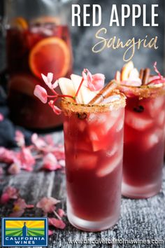 two glasses filled with red apple sanggraa and garnished with fresh flowers