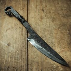 a large knife sitting on top of a wooden table