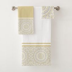 two towels hanging on the wall next to each other with yellow and white designs in them