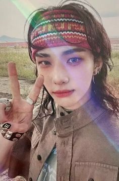 a young woman making the peace sign with her hand and wearing a knitted hat