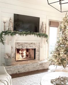 a living room with a christmas tree and a tv above the fire place in the fireplace