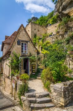 an old stone house with steps leading up to it