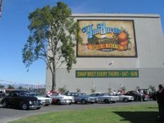 cars parked in front of a building with an advertisement on it