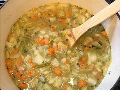 a wooden spoon in a pot filled with soup