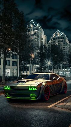 a car that is sitting in the street at night with green lights on it's headlights