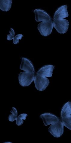 several blue butterflies flying in the dark