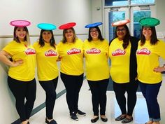 five women in yellow shirts with frisbees on their heads