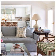 a living room filled with furniture next to a kitchen