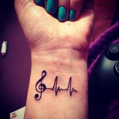 a woman's wrist tattoo with music notes on it