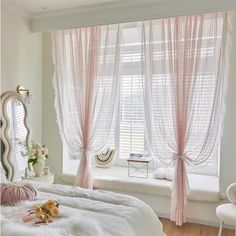 a bedroom with pink curtains and white furniture