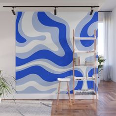 a blue and white wall mural with wavy lines in the center, on a wooden floor