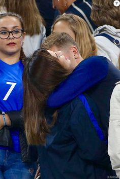 two people hugging each other at a sporting event