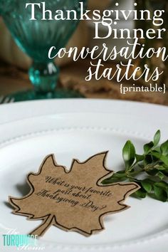 a white plate topped with a green leaf and a tag that says thanksgiving dinner conversation starter printable