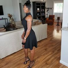 a woman standing in a living room next to a couch