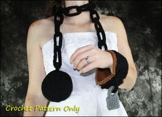 a woman wearing a crocheted black and brown necklace with two balls attached to it