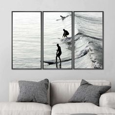 two paintings depicting surfers in the ocean on their surfboards, one is black and white