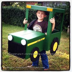 a young boy wearing a green tractor costume