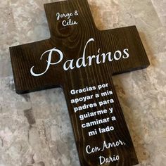 a wooden cross with the words person and latina written in white ink on it