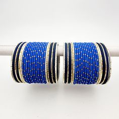 This elegant bangle set is designed in a stunning shades of blue with intricate gold accents. The set includes bangles for both arms, offering a harmonious blend of vibrant color and exquisite detailing. Luxury Blue Bangle For Anniversary, Cheap Blue Bohemian Bangle, Cheap Blue Bangle As A Gift, Luxury Blue Bangle For Wedding, Cheap Handmade Blue Bangle, Luxury Traditional Blue Bangle, Bangle Set, Gold Accents, Shades Of Blue