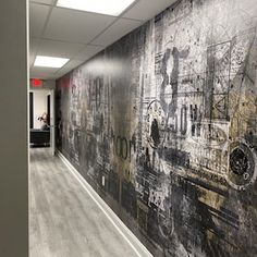 an office hallway with a large painting on the wall