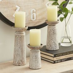 three candles sitting on top of a table next to a clock