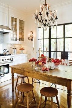 a kitchen with a wooden table surrounded by stools