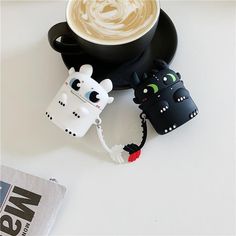 a cup of coffee is next to a cell phone holder with an animal on it