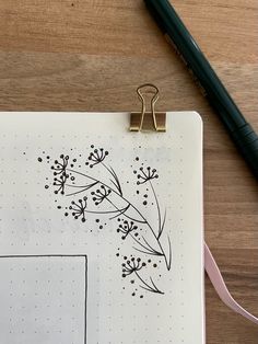 a notepad with some flowers on it next to a pen and a clipboard