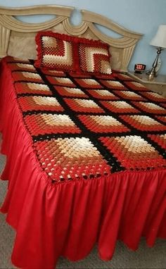 a bed with red and black bedspread on it