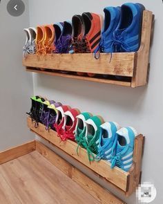 there are many pairs of shoes hanging on the wall in this shoe rack that is made out of wood