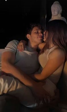 a man and woman cuddling in bed at night