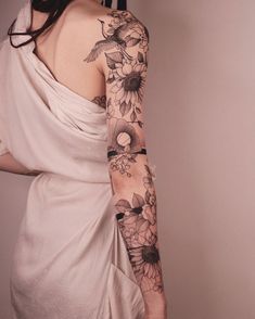 a woman wearing a white dress with tattoos on her arm