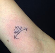 a woman's arm with a small tattoo design on the left side of her arm