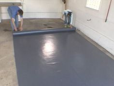 two men are working on an inflatable mattress that is being installed to the floor