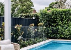 an outdoor pool surrounded by greenery and furniture