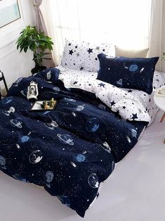 a bed covered in blue and white space themed bedspreads with stars on them