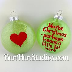 two green christmas ornaments with red hearts on them, one has a message and the other says maybe christmas perhaps means a little bit more