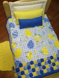 a toddler's bed with yellow and blue decorations on it, next to a wooden floor