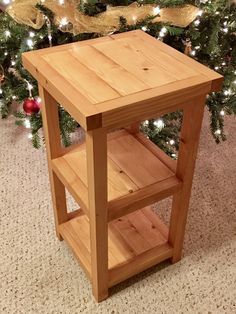 a small wooden table next to a christmas tree