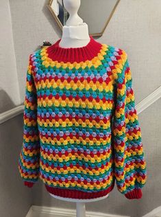 a multicolored sweater is displayed on a white mannequin's head