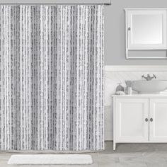 a bathroom with a sink, mirror and shower curtain in grey tones on the wall