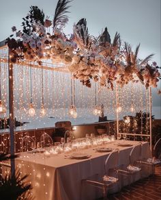 an outdoor dining area with lights and flowers