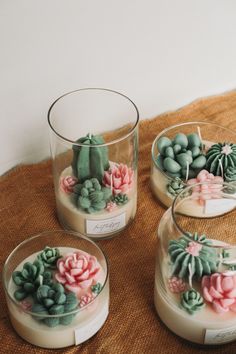 three glass vases filled with succulents sitting on top of a table