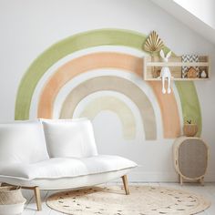 a white couch sitting in front of a rainbow wall mural