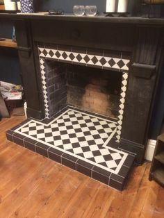 a fireplace with black and white tiles on it