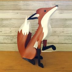 a wooden sculpture of a fox sitting on top of a table next to a wall