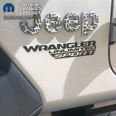 the jeep wrangler logo is on the side of a white vehicle with black lettering